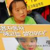 -2009년 7월 4일 오후 서울 여의도 산업은행 앞에서 열린 전국노동자대회에 서 쌍용차노동자의 한 자녀가 "해고는 살인이다"라는 팻말을 들고 있다.
