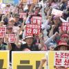 -8월 21일 오후 세종로공원에서 열린 ‘우편공공성 강화! 노조탄압 분쇄!를 위한 전국우정노동자 결의대회’에 참가한 우정노동자들이 손팻말을 들고 구호를 외치고 있다. 