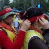-행진을 하고 있는 여성 노동자가 동료 여성 노동자의 머리띠를 매주고 있다.