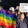 -30일 오후 서울 세종로 경찰서 앞에서 열린 난민 환영 집회에서 한 참가자가 ＂난민을 방어하는 것은 성소수자를 방어하는 데서 중요하다＂는 의미로 무지개 깃발을 들고 있다.
