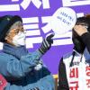 -약식집회 중 김 지도위원이 함께 걸어온 해고 노동자들 배려하며 햇빛을 가려주고 있다.