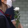 -추모제 참석자들이 국화를 들고 5년 전 사망한 19세 비정규직 노동자 김군을 추모하고 있다.