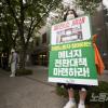 -기후행동 활동가들이 9월 25일 서울 탄소중립위원회 앞에서 1인 시위를 하며 정부의 기만적인 기후정책을 규탄하고 있다.