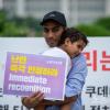 -7월 22일 오후 여의도 국회 앞에서 이집트 난민 가족들과 이들에 연대하는 한국인들이 함께 난민 인정을 요구하며 팻말 시위를 하고 있다.