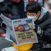 -1월 7일 오후 서울 세종대로에서 열린 윤석열 퇴진 집회에서 참가자들이 <노동자 연대> 신문을 읽고 있다.