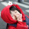 -2월 11일 오후 서울 시청역 인근 세종대로에서 열린 윤석열 퇴진 집회에서 한 아이가 수줍게 웃고 있다.