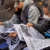-3월 25일 서울 세종대로에서 열린 윤석열 퇴진 집회에서 참가자들이 <노동자 연대> 신문을 읽고 있다.