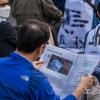-4월 22일 오후 서울 세종대로에서 열린 윤석열 퇴진 집회에서 참가자가 〈노동자 연대〉 신문을 유심히 읽고 있다.