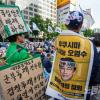 -5월 20일 오후 서울 세종대로에서 열린 윤석열 퇴진 집회 참가자가 후쿠시마 핵 오염수 방류를 규탄하는 현수막을 두르고 있다.
