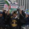 -2월 24일 오후 경복궁 인근을 지나던 관광객들이 팔레스타인 연대 행진에 함께 하고 있다.